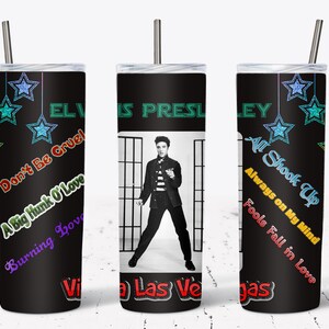 May include: A black tumbler featuring Elvis Presley with song titles and star accents. The tumbler has a black background with the words "Elvis Presley" in green. Song titles include "Don't Be Cruel" and "All Shook Up."