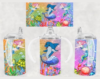 May include: A set of three sippy cups with a colorful ocean-themed design. Each cup features a different illustration of sea creatures, including mermaids, dolphins, and crabs, set against a sparkling background. The cups have clear handles and lids.