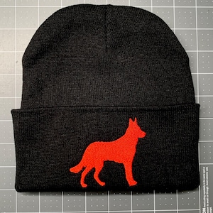 May include: Black knit beanie with a red embroidered silhouette of a dog.