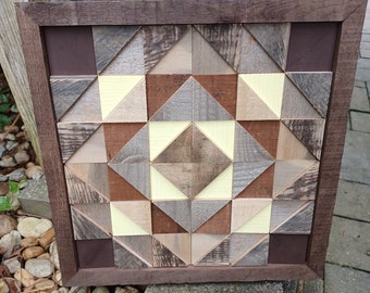 May include: A framed geometric wall art piece made of wood with a brown, tan, and yellow color scheme.
