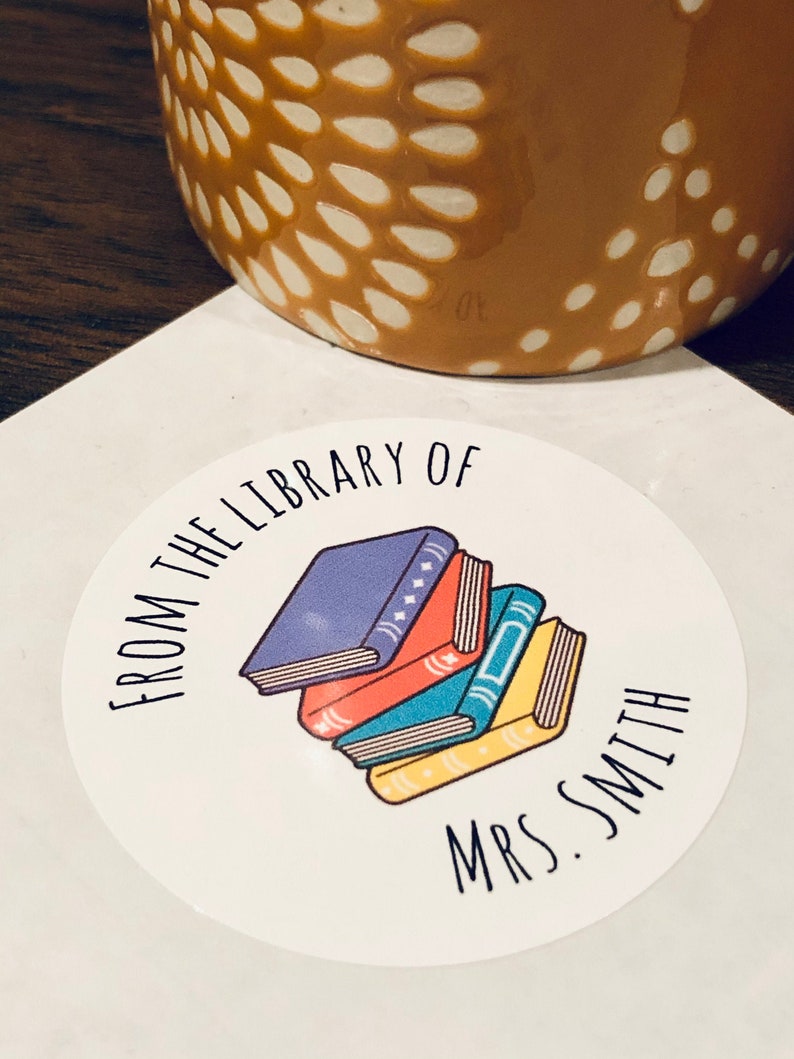 May include: A white round sticker with the text "From the Library of Mrs. Smith" and a stack of colorful books.
