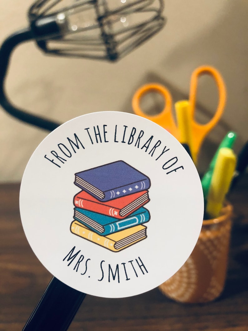May include: White round sticker with the text "From the Library of Mrs. Smith" and a stack of colorful books.