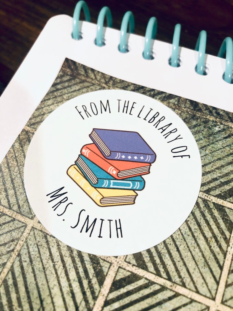 May include: White round sticker with the text "From the Library of Mrs. Smith" and a stack of colorful books.