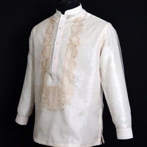 Timeless Elegance in Beige: Hand-embroidered on rich Organza fabric, it features a Chinese collar, cuff buttons and comes with an attached lining for added comfort. A symbol of tradition and sophistication for any special occasion.
