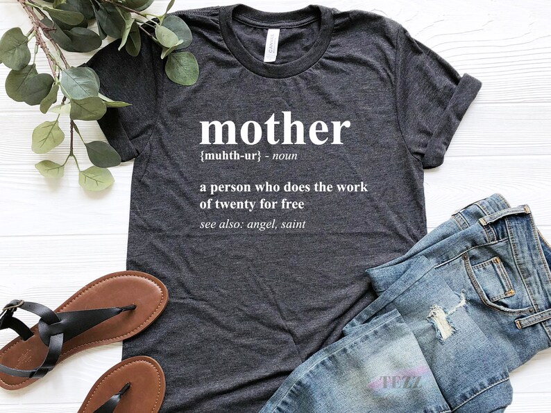 May include: A dark gray t-shirt with the word "mother" defined as "a person who does the work of twenty for free" in white text.