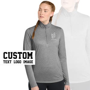 May include: Gray long-sleeve shirt with a quarter-zip closure. The shirt has a white logo with the text "COMPANY" and a geometric design.