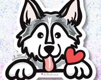 May include: A cartoon sticker of a husky dog holding a red heart. The dog is looking at the viewer with its tongue sticking out. The sticker has a white outline and the text "whattacharm" is written on the bottom.