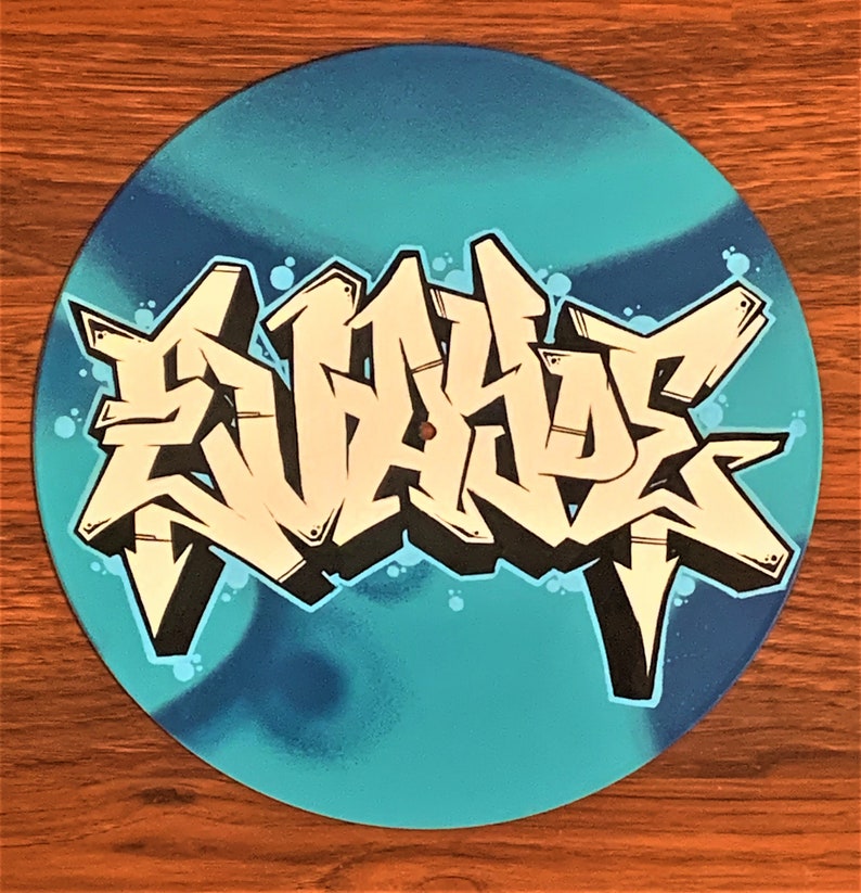 May include: A blue vinyl record with a white and black graffiti design that says "SKATE" in large letters.