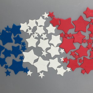 May include: A collection of blue, white, and red star-shaped decorations. The stars are arranged in a semi-circle pattern.