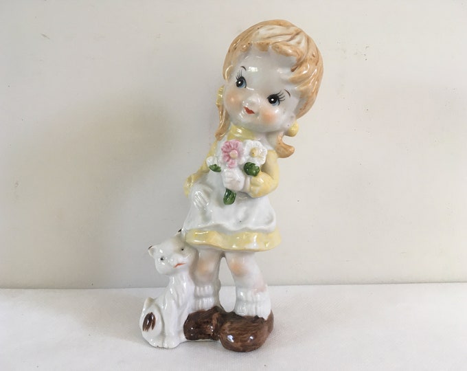 Cute porcelain girl accompanied by her cat, holding flowers, figurine from the 1970s