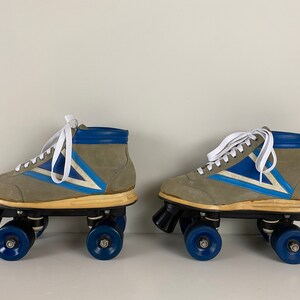 May include: A pair of vintage roller skates with gray suede boots, blue and white accents, and blue wheels.