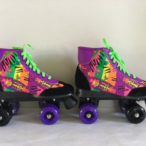 May include: A pair of purple, black, and neon green roller skates with a colorful, abstract print. The skates have black wheels with purple hubs.