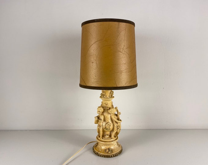 1950's beige cast resin cherub lamp base with a pig bladder lamp shade, lovely mid century design