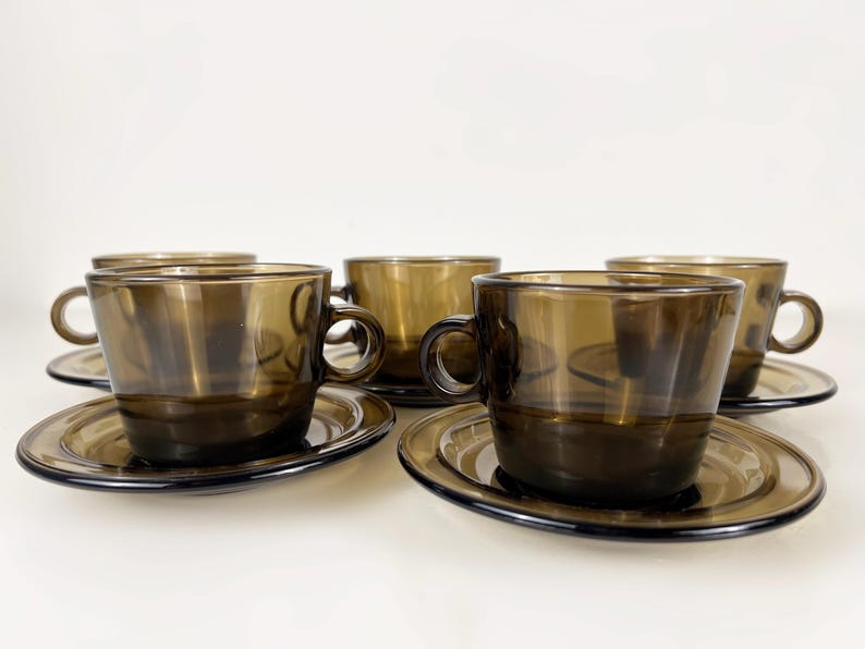 K&ouml;nnte beinhalten: Set aus f&uuml;nf braunen Glas-Teetassen und Untertassen. Die Tassen und Untertassen haben ein schlichtes, elegantes Design.