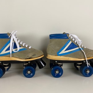 May include: A pair of vintage roller skates with gray suede boots, blue and white accents, and blue wheels.