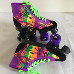 May include: A pair of purple and black roller skates with neon green laces and colorful graphic print. The print features flames, skulls, and the word "Socks".