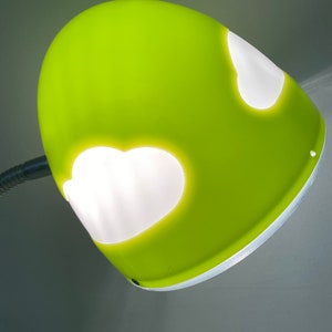 May include: A bright green desk lamp with a white, cloud-shaped cutout on the shade.