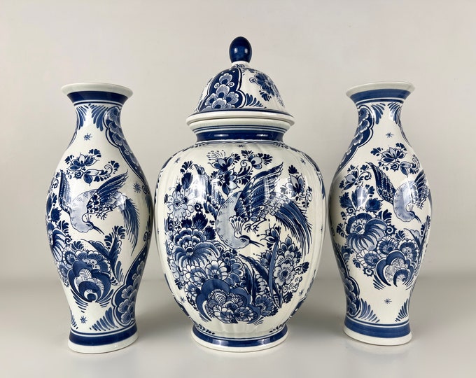 Delft blue cabinet set consisting of one large ginger pot and two vases, hand painted decor with flowers and birds. Delft Holland 1980s