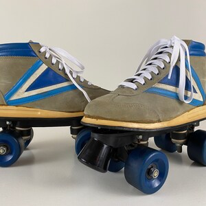 May include: A pair of vintage roller skates with gray suede boots, blue and white accents, and black wheels.