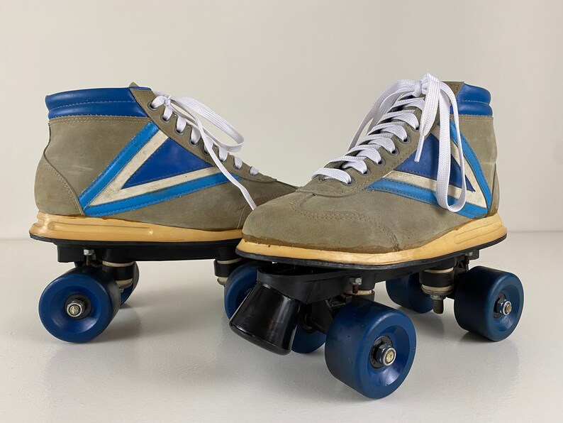 May include: A pair of vintage roller skates with gray suede boots, blue and white accents, and black wheels.