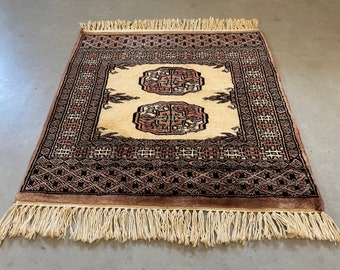 Oriental table rug, small carpet, table topper, table runner, black, off white and pink accents. 1960s style