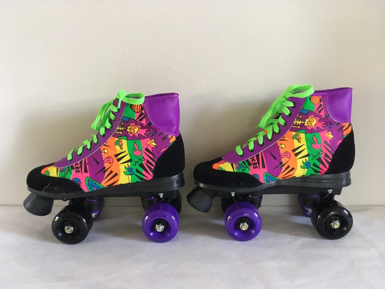 May include: A pair of black and purple roller skates with neon green laces. The skates have a colorful, abstract print with the word "Jack's" on them.