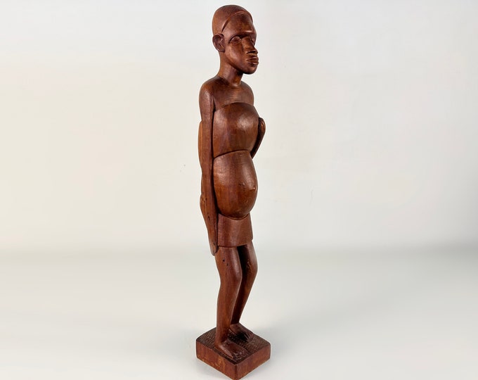 Stylish vintage statue of a pregnant African woman carrying a baby on her back, beautiful detailed carving. West Africa before 2000