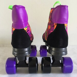 May include: A pair of black and purple roller skates with colorful abstract patterns on the boots. The skates have purple wheels and black frames.