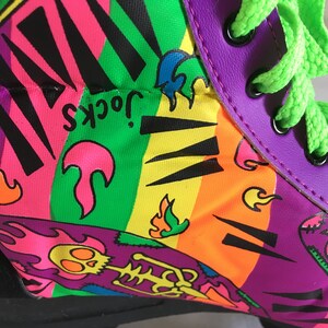 May include: Purple, green, yellow, orange, pink, and black roller skate with a graphic print of flames, a skeleton, and the text "Jock's".