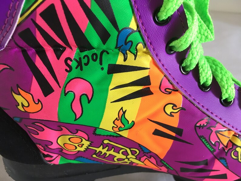 May include: Purple, green, yellow, orange, pink, and black roller skate with a graphic print of flames, a skeleton, and the text "Jock's".