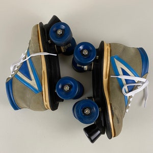 May include: A pair of vintage roller skates with gray suede boots, blue and white accents, and black wheels.