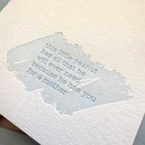 May include: A light blue card with a white background and a blue text overlay. The text reads: "this little peanut has all that he will ever need because he has you for a mother."