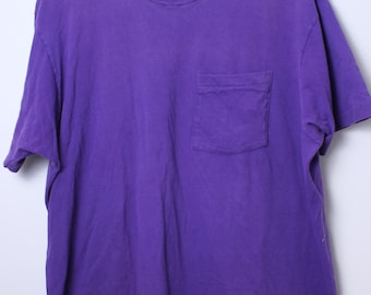 May include: A purple short-sleeved t-shirt with a pocket on the left side. The shirt is made of a soft, comfortable fabric.