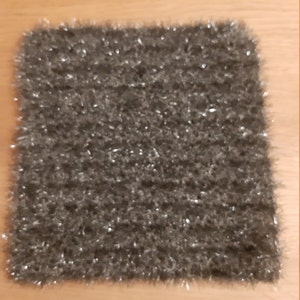 Könnte beinhalten: Ein quadratischer, grauer, flauschiger, glitzernder, gestrickter Teppich.