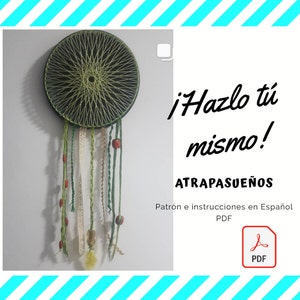 May include: A green and black dreamcatcher with a white lace and green string hanging from it. The dreamcatcher is on a white wall with the text "¡Hazlo tú mismo! ATRAPASUEÑOS Patrón e instrucciones en Español PDF" in black and red text. A red PDF icon is in the bottom right corner.