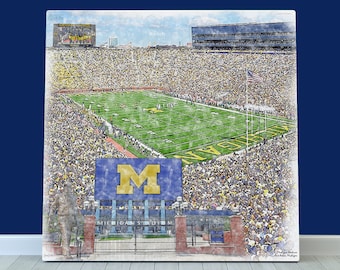 May include: A watercolour illustration of a football stadium with a large crowd of people. The stadium is filled with fans wearing yellow and blue, and the pitch is green. A large sign with the letter "M" is visible in the foreground. The text "Michigan Stadium" is visible below the sign.