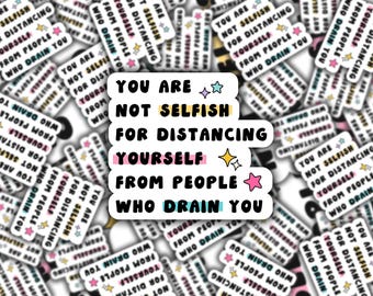 Op de afbeelding: Witte sticker met de tekst "YOU ARE NOT SELFISH FOR DISTANCING YOURSELF FROM PEOPLE WHO DRAIN YOU" in zwarte letters. Het woord "YOURSELF" is roze gemarkeerd. Decoratieve sterren zijn inbegrepen.