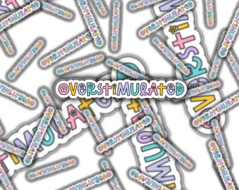 Può includere: Una collezione di adesivi con la scritta "OVERSTIMULATED" in un font colorato e giocoso. Gli adesivi presentano colori pastello come rosa, blu, giallo e viola, con accenti floreali e geometrici. Gli adesivi sono sparsi su uno sfondo bianco.