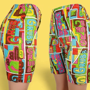 Peut inclure: Shorts vintage aux motifs g&eacute;om&eacute;triques color&eacute;s. Le mot "GRUBB" est r&eacute;p&eacute;t&eacute; dans un motif avec des couleurs rouge, vert, bleu, jaune et marron. Fermeture boutonn&eacute;e, style r&eacute;tro.