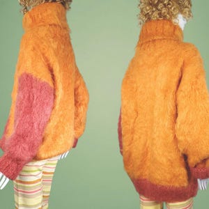 May include: A fuzzy orange and pink sweater with a turtleneck.