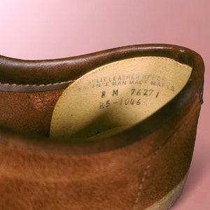 May include: Close-up of the inside of a brown leather shoe. The label reads "Split Leather Upper", "Science Man Made Mat'l", "8 M", "76271", and "R5-1046".