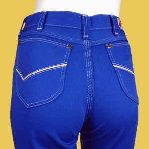 May include: Blue denim jeans with white stitching and a contrasting red and white stitch detail on the back pockets.