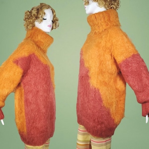 May include: Two fuzzy sweaters in orange and red color block patterns. The sweaters have a turtleneck style.