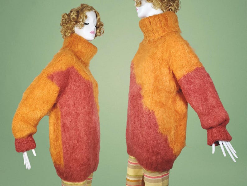 May include: Two fuzzy sweaters in orange and red color block patterns. The sweaters have a turtleneck style.