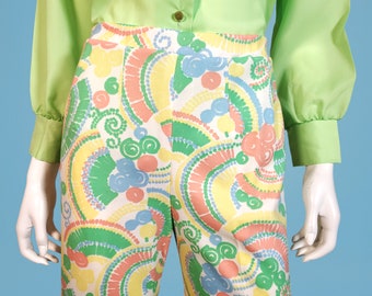 May include: A pair of pants with a white background and a colorful abstract pattern featuring green, pink, yellow, and blue swirls and circles.