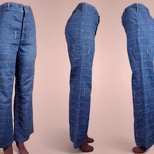 K&ouml;nnte beinhalten: Blaue Jeans mit horizontalen Steppdetails und dekorativen rechteckigen Akzenten. Die Jeans hat eine hohe Taille und ein ausgestelltes Bein. Die N&auml;hte sind in einem helleren Blauton gehalten und bilden einen Kontrast zum dunkleren Denim. Etwa 100 cm lang.
