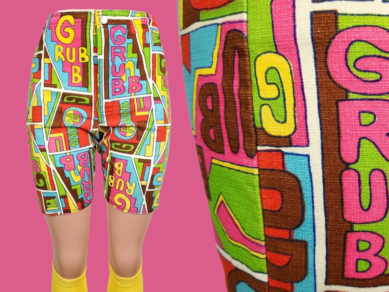 Peut inclure: Shorts vintage color&eacute;s avec un motif g&eacute;om&eacute;trique audacieux. Les shorts pr&eacute;sentent le mot "GRUBB" en grandes lettres, sur un fond de formes rouges, bleues, vertes et marron. Les shorts sont pr&eacute;sent&eacute;s sur un mannequin avec des chaussettes jaunes.