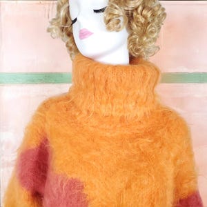 May include: A fluffy orange and pink turtleneck sweater with a high neck.