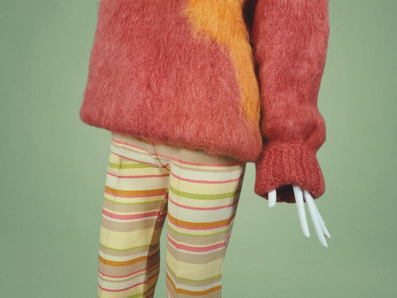 May include: A fuzzy pink and orange sweater with a striped pattern on the pants.