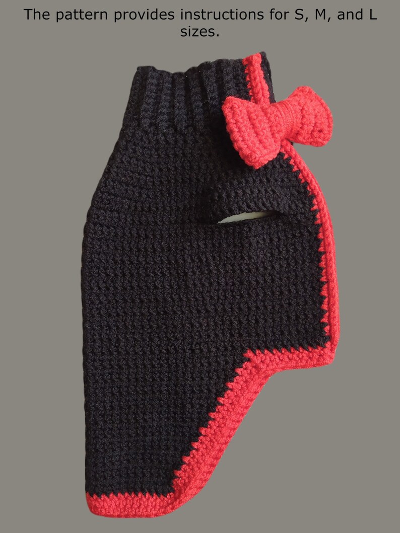 May include: Black crocheted dog sweater with a red crocheted bow. The sweater has a red trim around the edges.